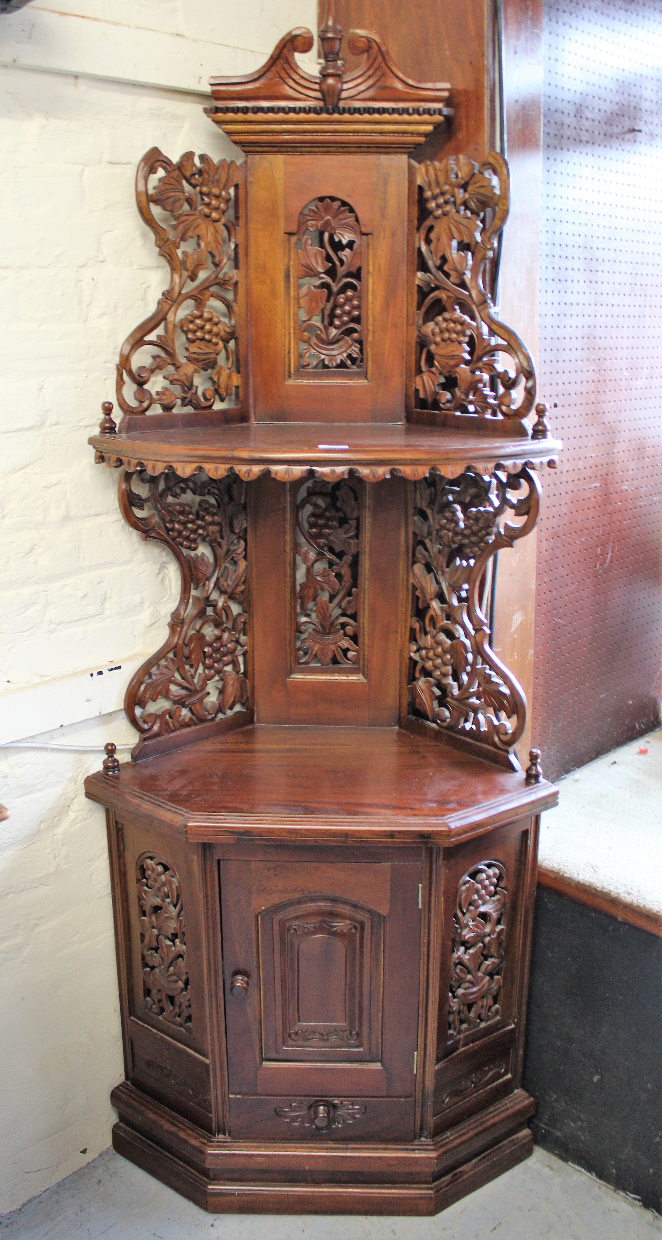 Late 20th Century hardwood corner cupboard having grapevine carved and pierced decoration, with