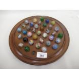 Solitaire board and a collection of antique marbles Board is 28cms in diameter. Diameter of smallest