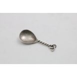 AN ARTS AND CRAFTS CADDY SPOON with a hammered drop-shaped bowl and a wire stem and terminal,