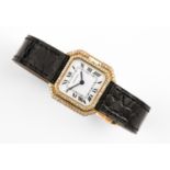 A LADY'S GOLD AND DIAMOND WRISTWATCH BY CARTIER the signed white enamel dial with Roman numerals,