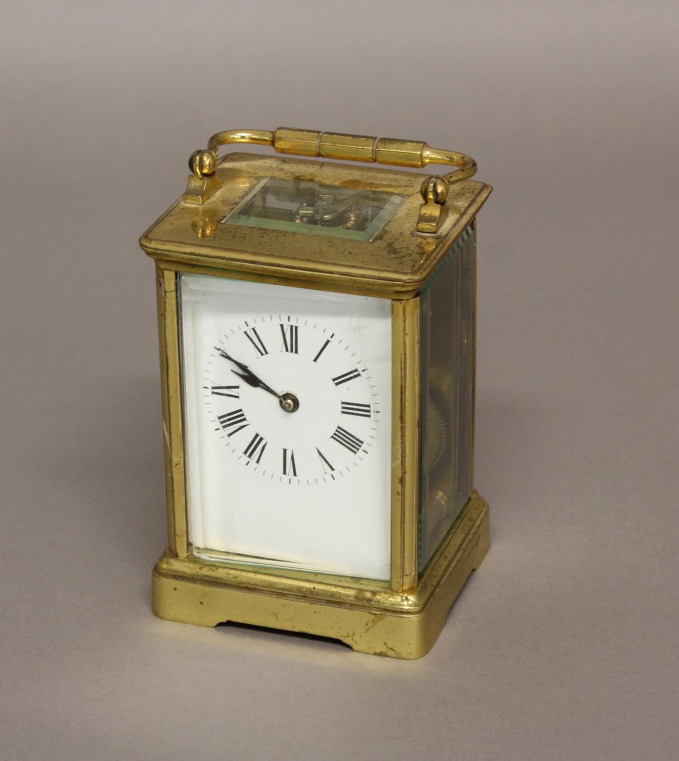 A FRENCH BRASS CARRIAGE CLOCK, the enamelled dial on a brass eight day movement striking half hourly