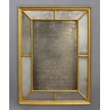 EARLY 19TH CENTURY GILT WALL MIRROR, with rectangular centre plate and mirrored margins between