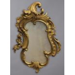 A REGENCY GILT WOOD WALL MIRROR, the scrolling foliate frame carved with flowerheads, height 90cm