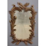 A CONTINENTAL CARVED LIME WOOD WALL MIRROR, of stiff leaf form, height 70cm