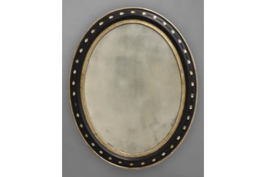 AN IRISH EBONISED AND GILT OVAL WALL MIRROR, 19th century, the frame inset with cut glass studs,