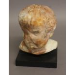 A ROSE VEINED MARBLE BUST OF A CHILD, mounted on a square base, height 26cm