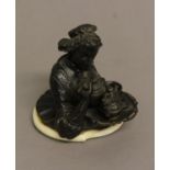 A FRENCH BRONZE INKWELL, 19th century, depicting a woman holding a tray, the hinged head opening