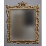 A LIMEWOOD WALL MIRROR, the rectangular plate set within a scrolling frame, height 85cm, width 62cm