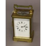 A FRENCH BRASS CARRIAGE CLOCK, the enamelled dial on a brass eight day movement striking half hourly