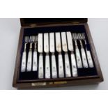 A LATE VICTORIAN CASED SET OF TWELVE PAIRS OF DESSERT KNIVES AND FORKS with mother of pearl handles,