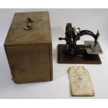 WILCOX & GIBBS SEWING MACHINE a boxed cast iron sewing machine, mounted on a wooden plinth and