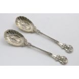 A PAIR OF VICTORIAN FRUIT SERVING SPOONS in the aesthetic manner with gilt bowls and incuse