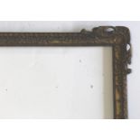 A CARVED AND GILDED PICTURE FRAME the corners with pierced leafy scroll and shell decoration, floral