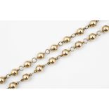 A 9CT GOLD BALL NECKLACE formed with uniform 9ct gold balls each separated by a circular gold