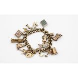 A 9CT GOLD CURB LINK BRACELET with padlock clasp and suspending assorted gold charms, 18cm long,