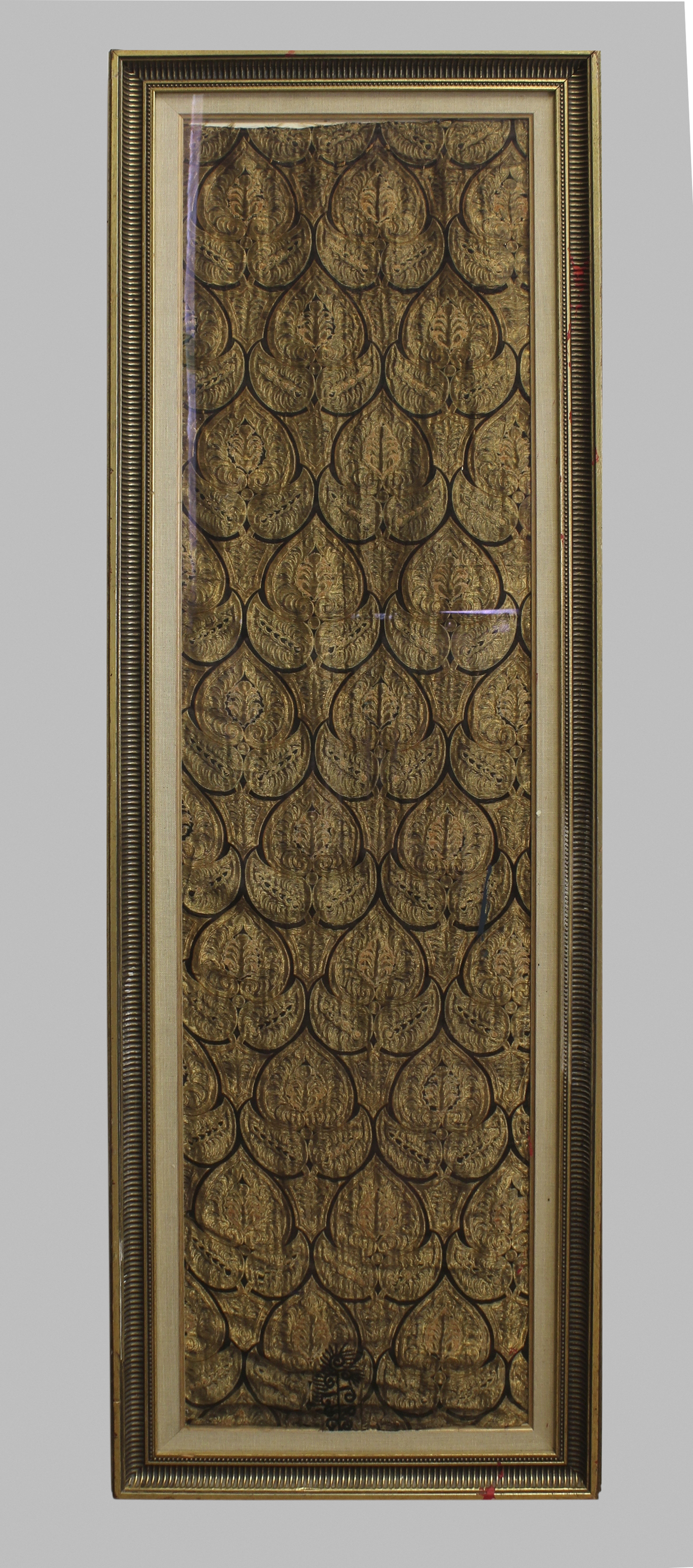 AN EASTERN SILK AND WIREWORK PANEL, with a repeating stylised leaf motif, framed and glazed, panel