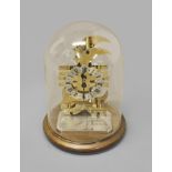 A MINIATURE GILT METAL SKELETON CLOCK, in the form of a Pound Sterling sign, atop a 500g 999 fine