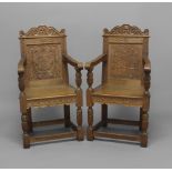 A PAIR OF CARVED OAK HALL CHAIRS, early 20th century, the scrolling top rail carved with a mask
