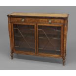 A REGENCY SATINWOOD AND CROSSBANDED SIDE CABINET, the rounded rectangular top above a single