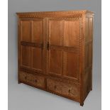 A 1920'S INLAID CEDAR WOOD WARDROBE, the carved cornice above an inlaid frieze and doors with carved