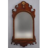 AN 18TH CENTURY FRET CARVED WALL MIRROR, the arched and bevelled plate within a parcelgilt border,