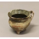 AN EARLY TERRACOTTA COOKING POT, possibly 16th century, with remains of green rim glaze, on three