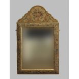 A STUMPWORK FRAMED CUSHION MIRROR, the shaped pediment decorated with flowers and scrolling