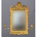 A 19TH CENTURY GILT WALL MIRROR, the shaped rectangular plate set within a gesso frame with stylised