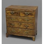 A GEORGE II WALNUT BACHELOR'S CHEST, the feather-banded top above a brushing slide and an