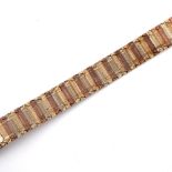 A 9CT THREE COLOUR GOLD BRACELET. formed with alternate panels of gold, with engine turned