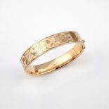 A 9CT GOLD HALF HINGED BANGLE. with foliate engraved decoration to one side, internal measurements 6