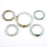 A JADE BANGLE. internal measurement 5.5cm dia., together with four child's jade bangles, total