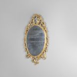 A GILTWOOD WALL MIRROR. 19th century, the oval mirror plate in a scrolling floral Rococo style