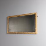 A GEORGE III GILT WALL MIRROR. the bevelled plate in a gilt scrolling border, 42cm x 83cm. * Some