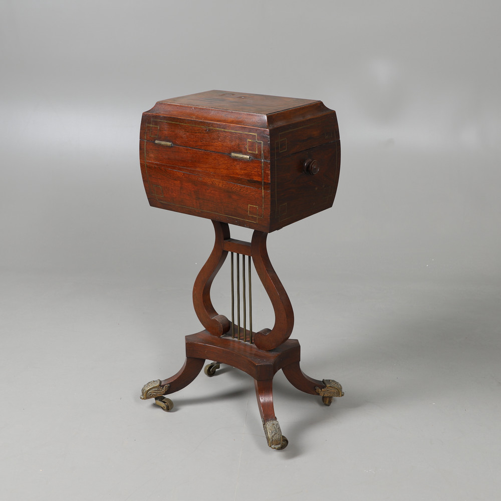 A REGENCY ROSEWOOD AND BRASS INLAID TEAPOY. the rounded sarcophagus top with turned handles