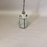 AN ARTS AND CRAFTS COPPER LANTERN. of glazed cylindrical form with flower finial and rigid chain