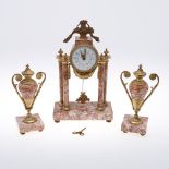 A FRENCH CLOCK GARNITURE. the 3 1/2" porcelain dial in an engine turned gilt drum case on gilt and