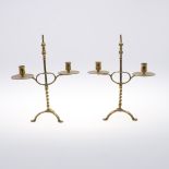 A PAIR OF BRASS ADJUSTABLE CANDELABRA. on turned and twist stems with twin sconces and tripod