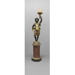 AN ITALIAN POLYCHROME BLACKAMOOR TORCHÈRE. the figural column in gilt floral robes holding aloft a