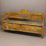 AN EASTERN SETTLE. possibly Indonesian, with a carved and shaped top and sides with turned spindles,