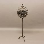 A WROUGHT IRON GIMBAL MARITIME OIL LAMP. of spherical form, on a wrought iron tripod stand, height