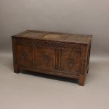 A 17TH CENTURY OAK COFFER. with front with carved floral and diamond panelling, the sides and back