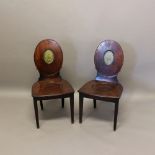 A PAIR OF 19TH CENTURY MAHOGANY HALL CHAIRS. the oval backs with painted griffin crests, on tapering