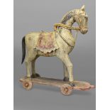 A LARGE INDIAN FOLK ART CARVED CEREMONIAL WOODEN HORSE. the saddle and tack polychrome painted on
