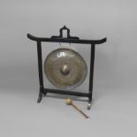 A 19TH CENTURY BURMESE GONG. on an ebonised frame with glazed aperture to the top rail, the