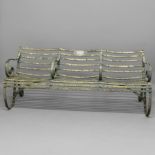 A CAST IRON BENCH FROM LONDON ZOO. with three seats on scrolling supports, bearing plaque that reads