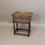 A 17TH CENTURY CARVED OAK BIBLE BOX. with a half hinged top and foliate lunette carving, on a