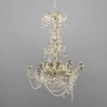 A TWELVE LIGHT CRYSTAL CHANDELIER. early 20th century, with four tiers of glass drops and swags