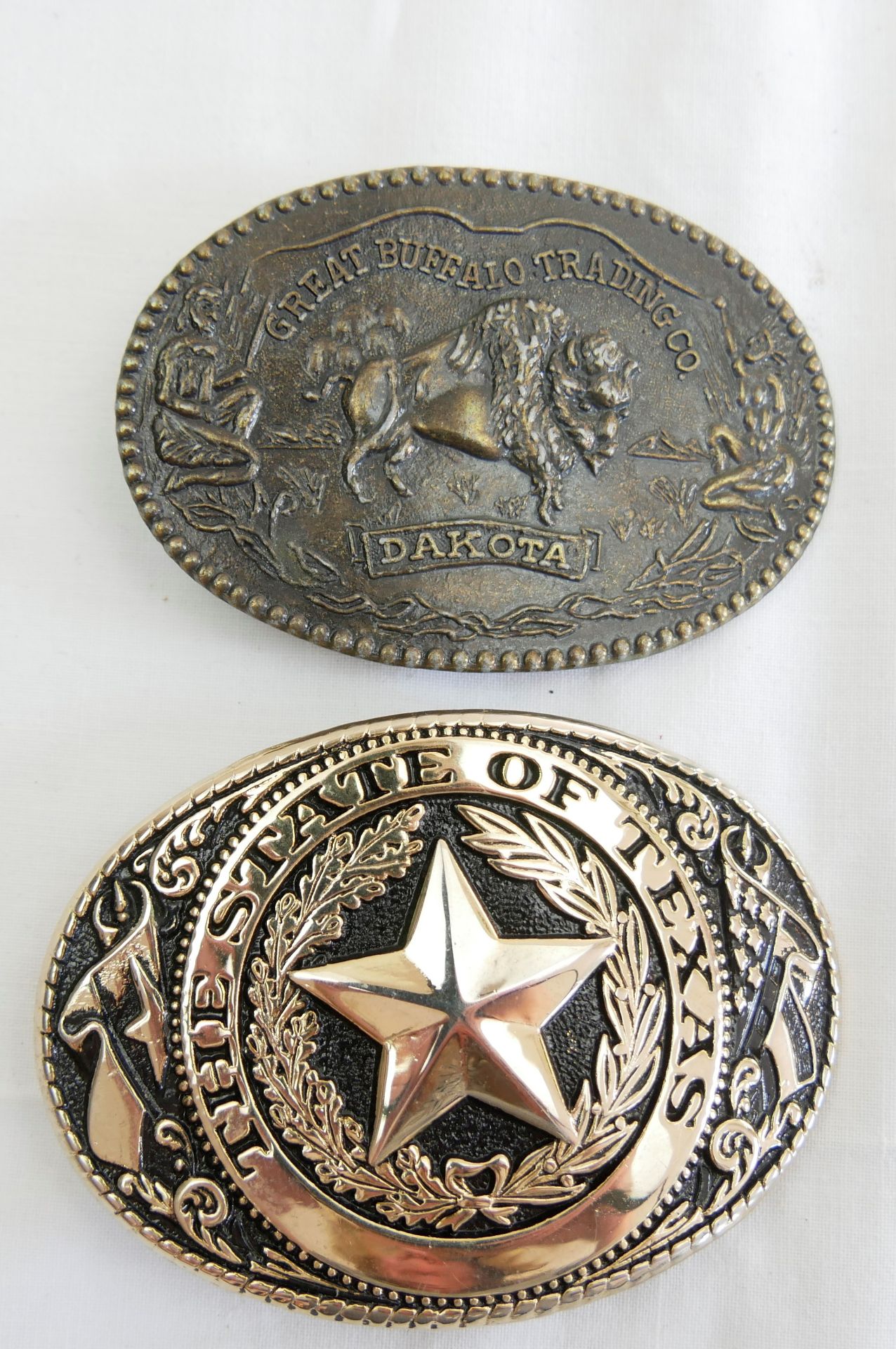 2 Gürtelschnallen, 1x The State of Texas, 1x Great Buffalo Trading Co. Dakota