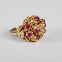 A 9CT GOLD AND RUBY COCKTAIL RING, CIRCA 1970'S, SET WITH 8 ROUND FACETED RUBIES, RING SIZE M.